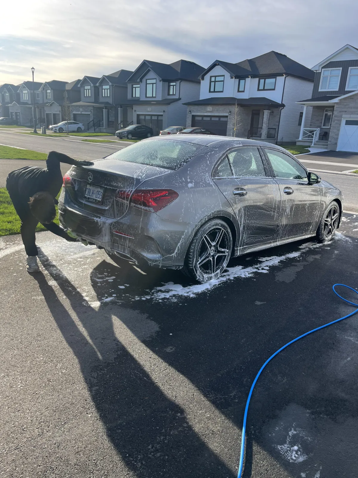 White Corvette with roof down and white Mercedes in the background