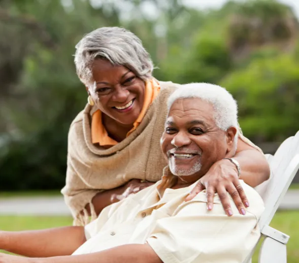  A happy middle-aged couple sharing a meal at an outdoor table, enjoying olives and bread together.