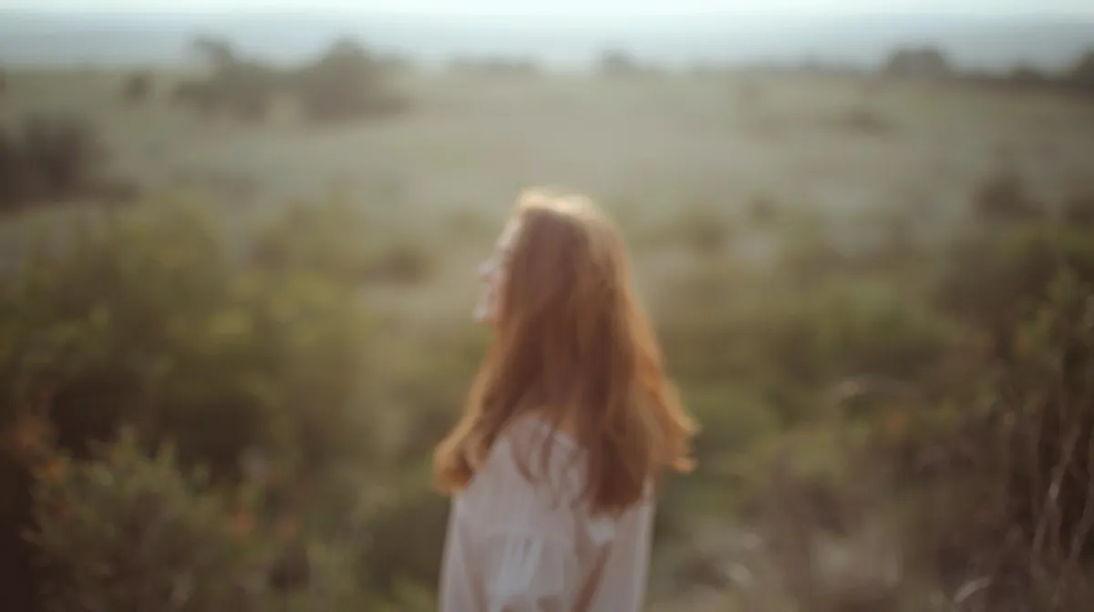 Photograph of a woman with long ginger hair, walking gently in nature. Soft colours above text which reads ‘Compassion Practice’.