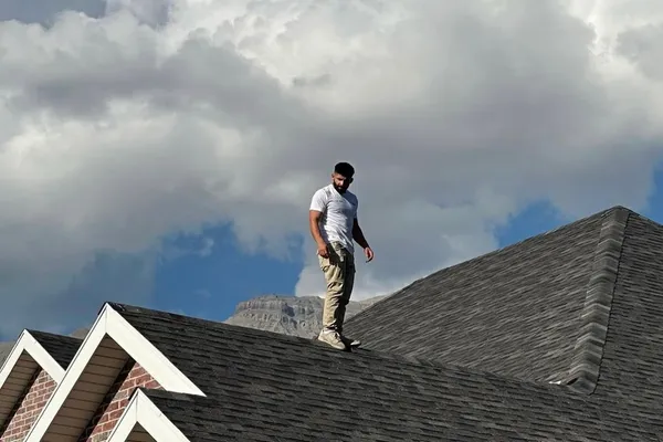 Roofing specialist performing a detailed roof inspection on a residential home in Utah