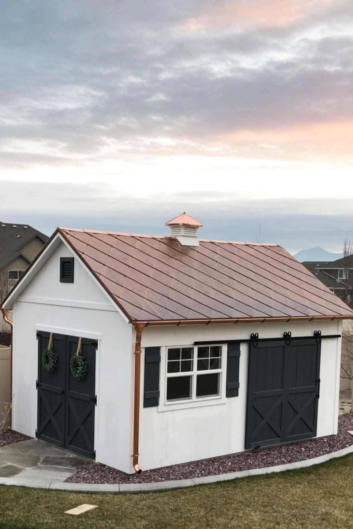 Copper gutter and downspout system installed on custom shed in Alpine Utah with metal roof and premium exterior detailing