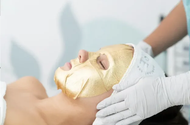 Client receiving the advance gold skin tightening treatment with the gold mask by Lindsay Rose Ali at Lindsay Rose Beauty in Mansfield Texas 
