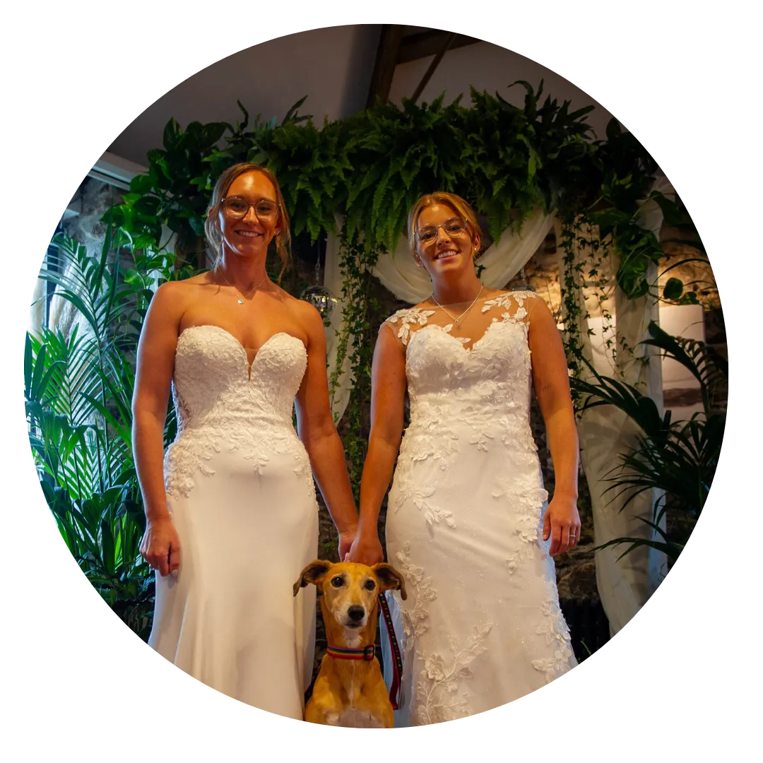 Two Brides in Front of Plant Backdrop