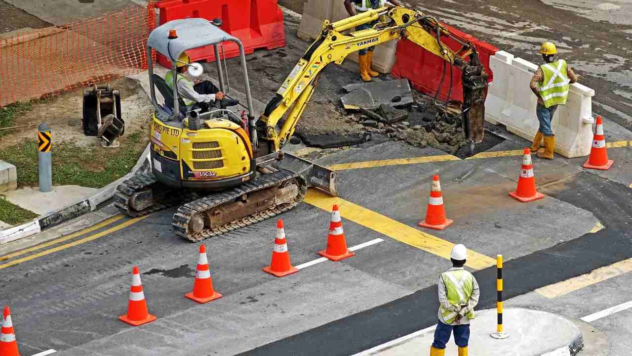 A group of construction workers are working on a road.