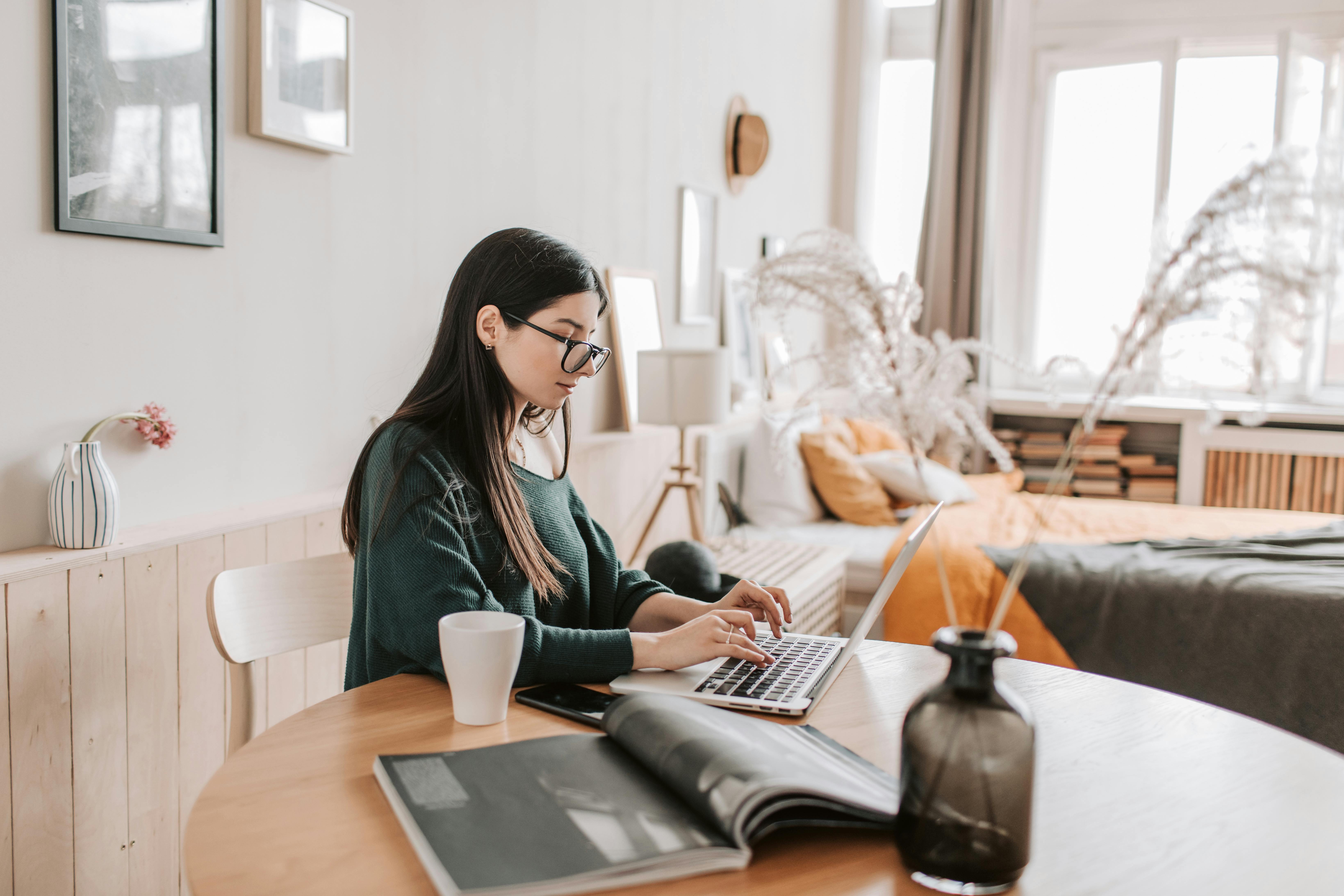 woman sitting at desk typing on keyboard slightly smiling