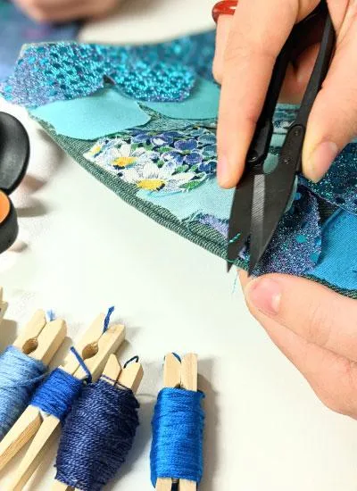 Blue embroidery threads with girl snipping fabric threads