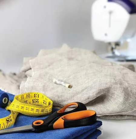 Fabric, scissors, tape measure, threads and a sewing machine
