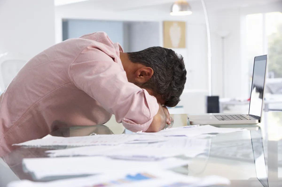 frustrated man with head on desk