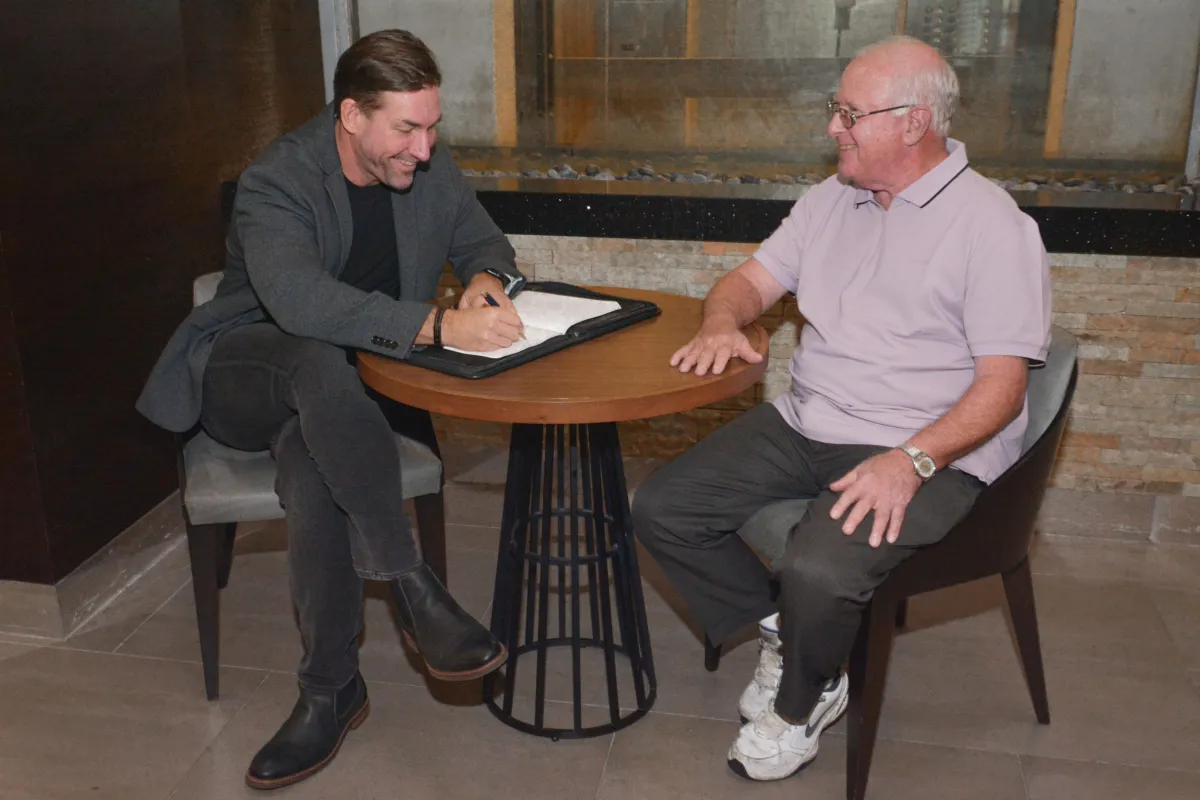 Dr. Mort sitting at a table being interviewed.