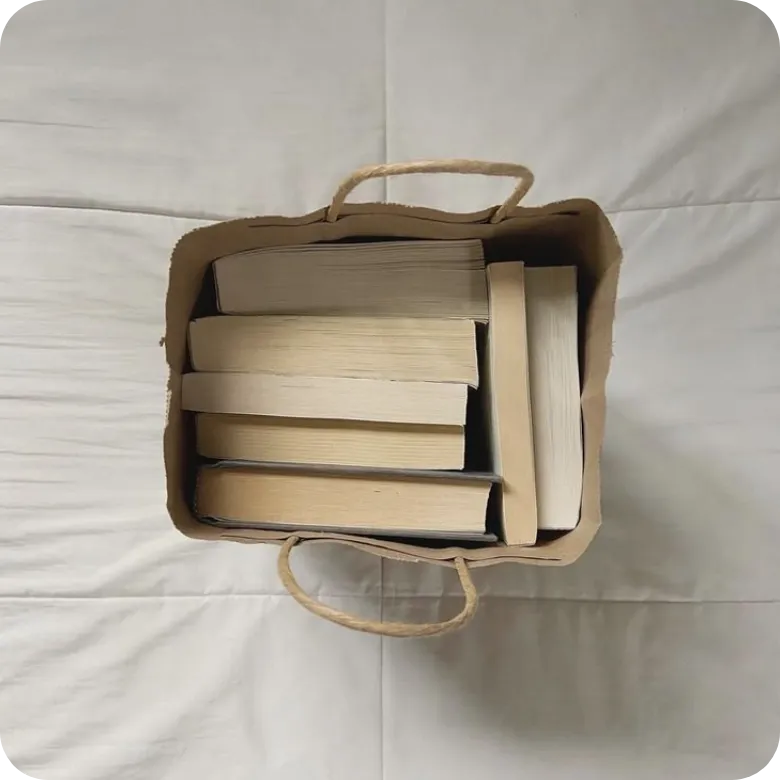 Stack of published premium business books and branded tote bag