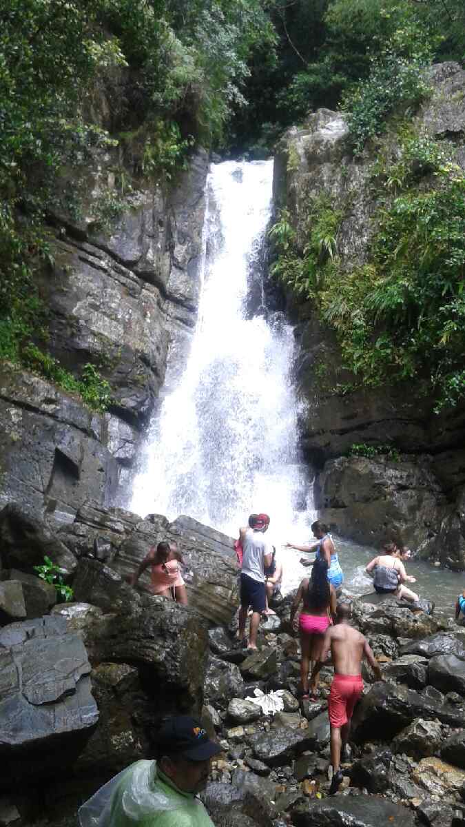 Couples climbing waterfall