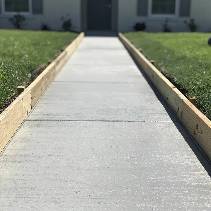 Freshly poured concrete sidewalk with form boards on a residential job site in Lake City, Florida