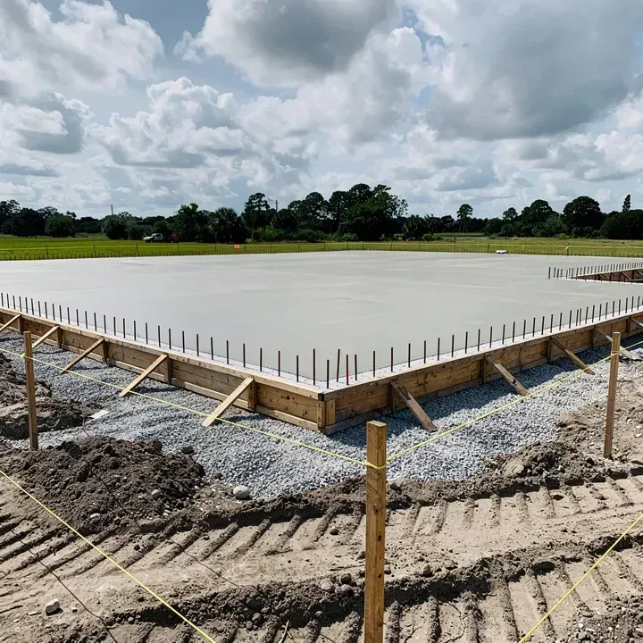 Freshly poured residential concrete foundation with rebar and form boards on a job site in Lake City, Florida