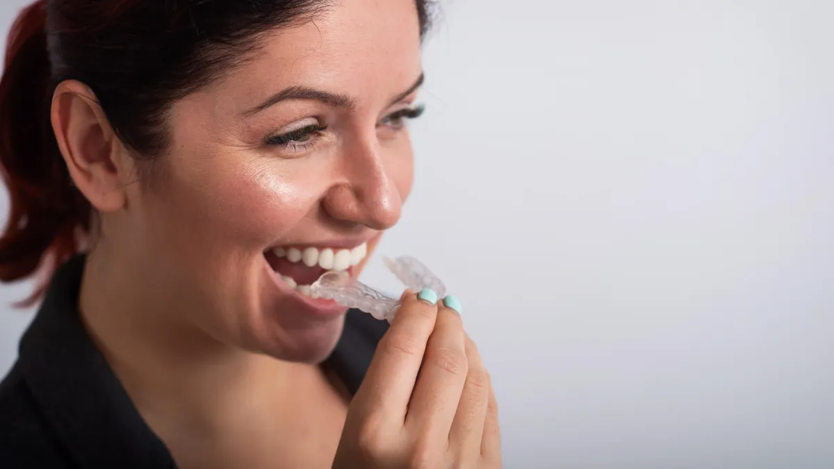 professional woman puts on Invisalign clear aligners