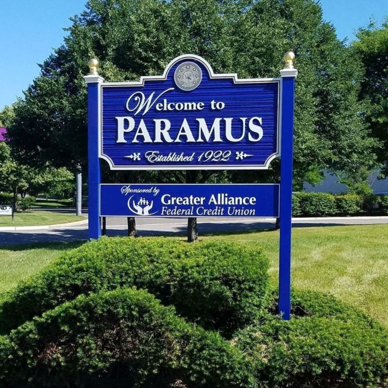 Paramus, NJ Town sign surrounded by bushes on summer day