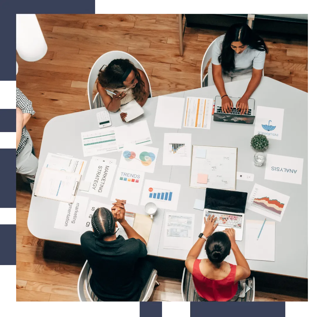 A diverse group of business people celebrating or collaborating in a modern office setting, representing teamwork and success.