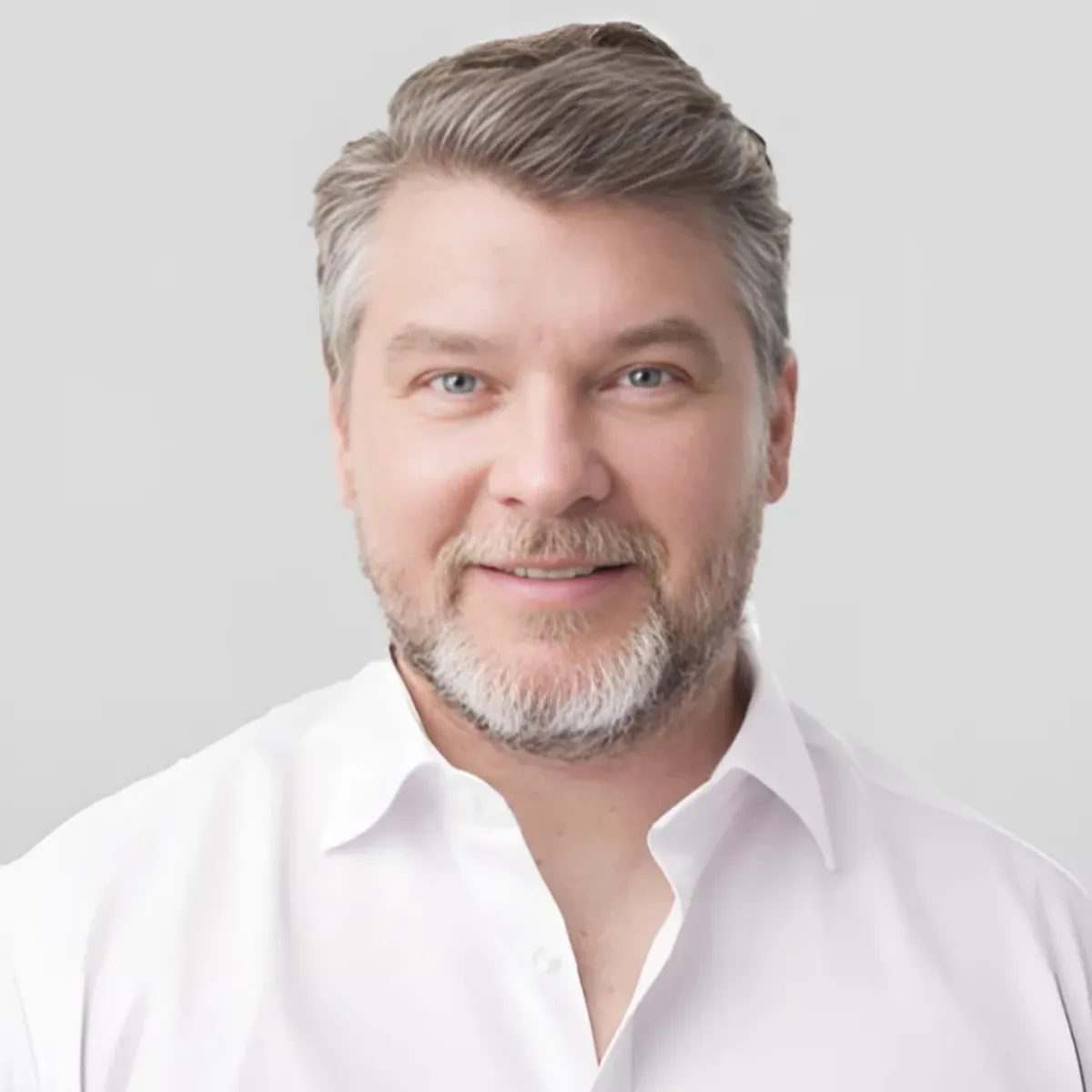 Portrait of a smiling male aesthetic specialist at Elida Aesthetic, representing expertise in beauty treatments.