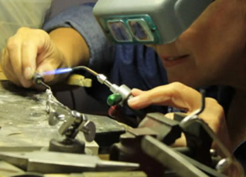 Jeweler soldering a ring on the bench.