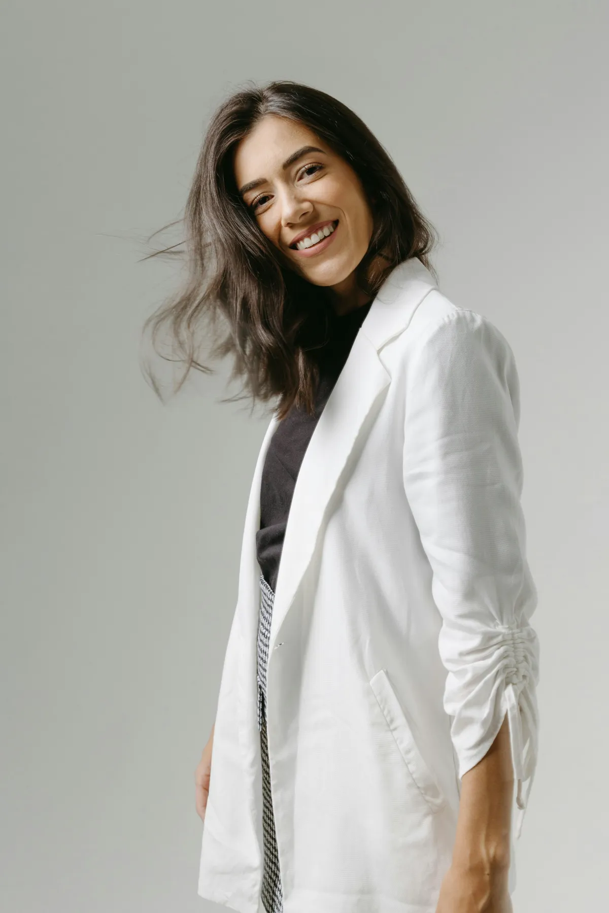 a smiling happy woman wearing a white suit smiling to camera