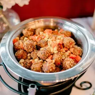 Hot party trays and buffet warmers serving savory meatballs at a corporate event.