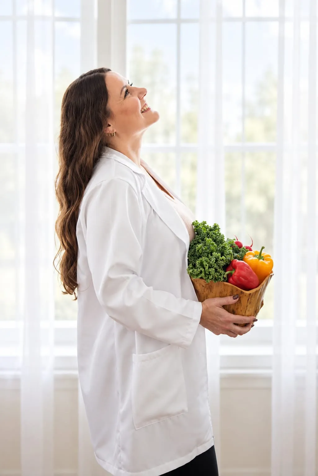 Sherine James holding a bowl of fresh vegetables