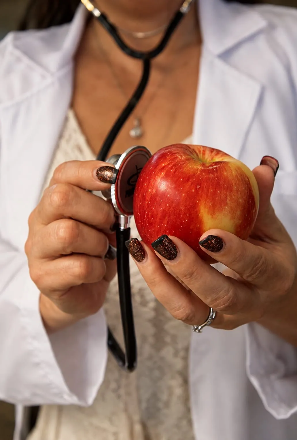 An apple held beside a stethoscope