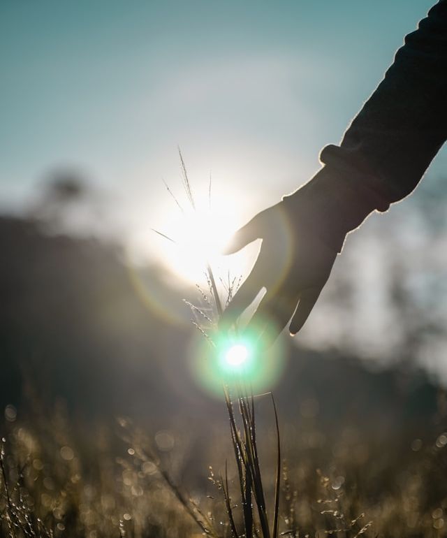hand touching an orb of light