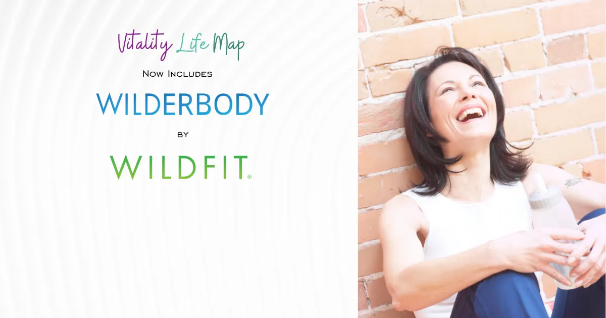 Woman leaning up against a brick wall with water bottle happy about the WILDFIT way