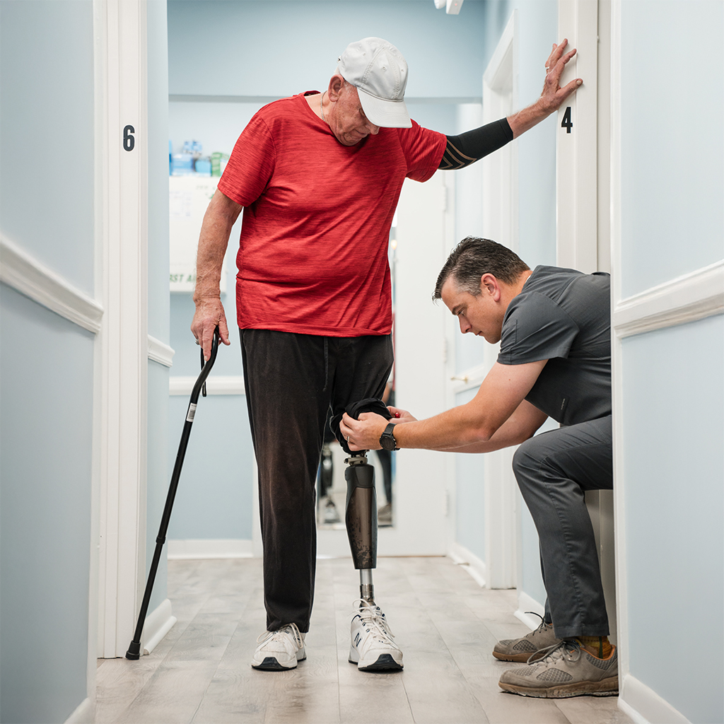elderly man with full leg prosthetic gets adjusted at floyd brace