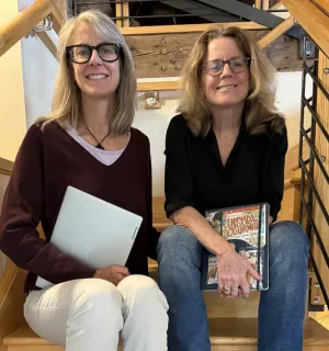 Portrait of KindWrite co-founders Valerie Berton and Diana Friedman sitting on a staircase