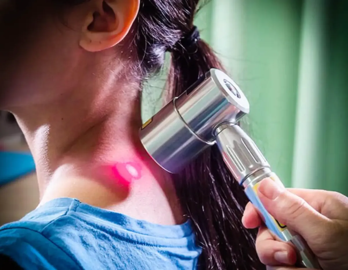 LZR7 laser light therapy being applied to a patient's neck at Gonstead Chiropractic Center in Fort Mill, SC, to reduce inflammation and accelerate healing.