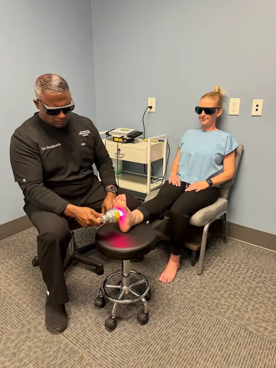 A patient receiving non-invasive laser therapy for foot pain at Gonstead Chiropractic Center in Fort Mill, South Carolina.