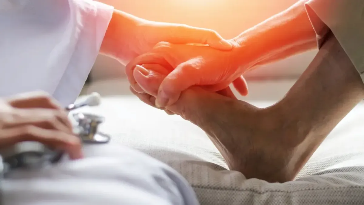 A chiropractor in a white lab coat performing a manual manipulation and adjustment on a patient's foot for chronic ankle pain relief in Fort Mill, SC.