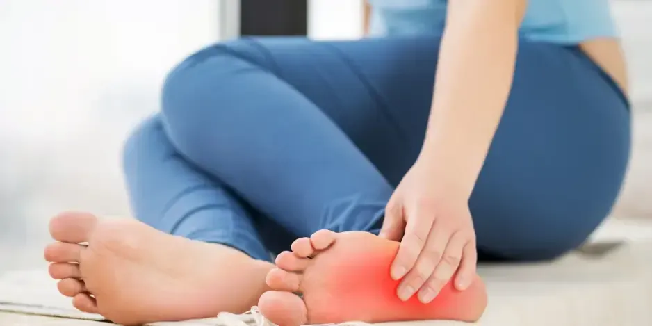 Close-up of a patient holding a foot with highlighted arch pain, showing soft tissue inflammation treated with chiropractic care for plantar fasciitis in Fort Mill, SC.