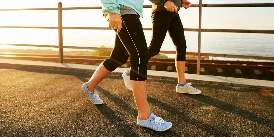 Two people power walking along a path showing healthy foot mechanics and ankle mobility achieved through plantar fasciitis treatment in Fort Mill, SC.