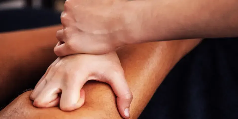 Hands applying targeted soft tissue therapy to a patient's calf muscle by a chiropractor for plantar fasciitis in Fort Mill, SC.
