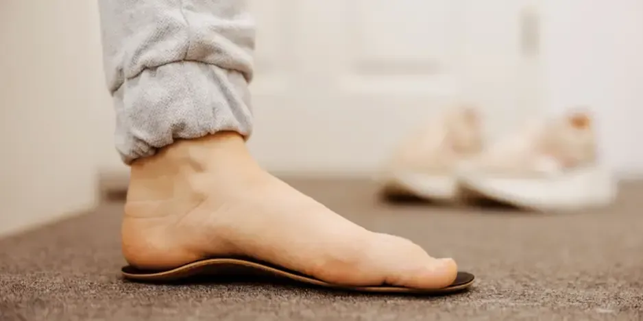 Bare foot standing on a supportive orthotic shoe insole recommended for heel pain treatment and plantar fasciitis in Fort Mill, SC.