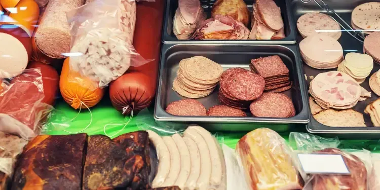 Selection of processed meats at a deli counter, an inflammatory food to avoid for chronic heel pain and plantar fascia recovery in Fort Mill, SC.