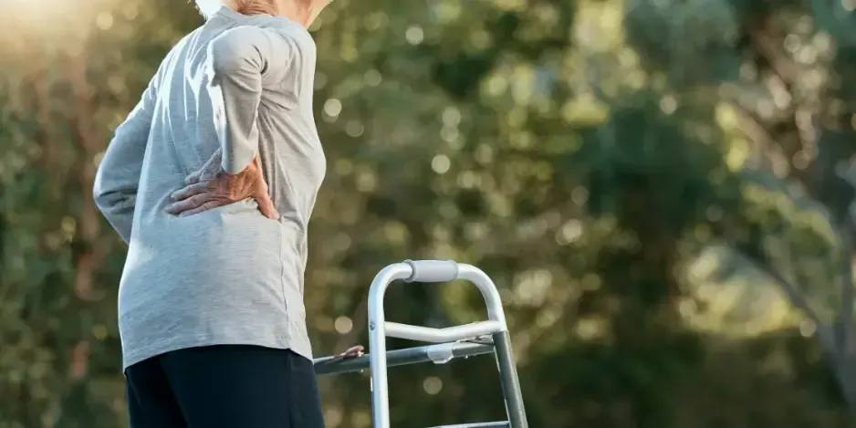 Senior woman experiencing osteoporosis back pain and mobility issues receiving chiropractic care in Fort Mill SC.