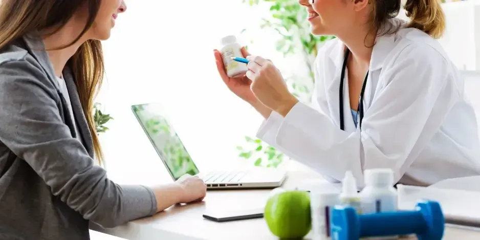 Healthcare professional reviewing vitamins and supplements with a patient