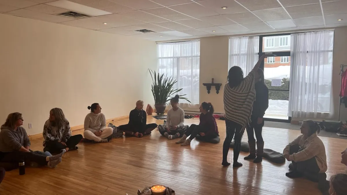 Participants réunis en cercle dans une salle pour un soin énergétique de groupe