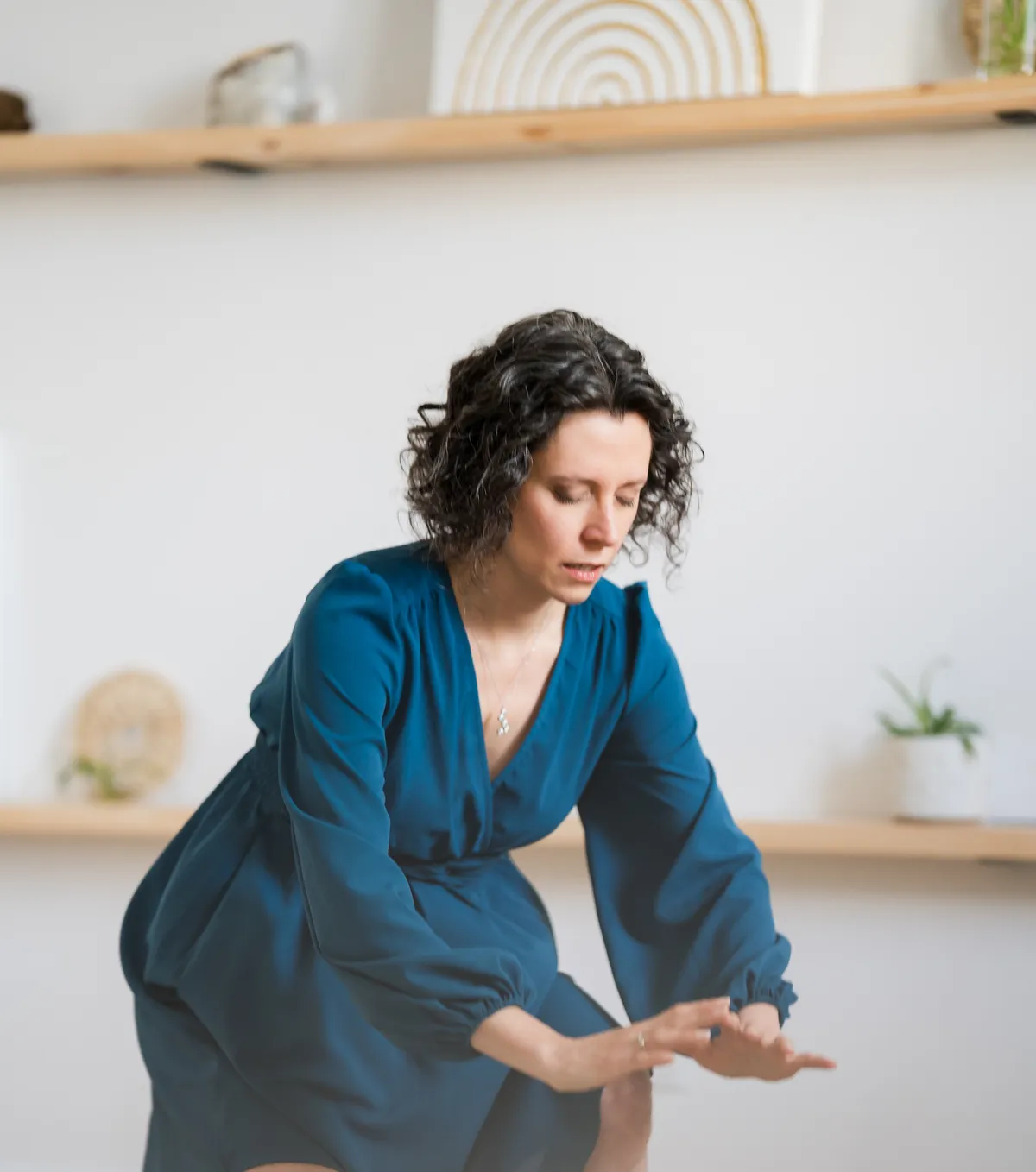 Annie Burelle, praticienne en soins énergétiques, levant les bras vers le soleil en pleine nature