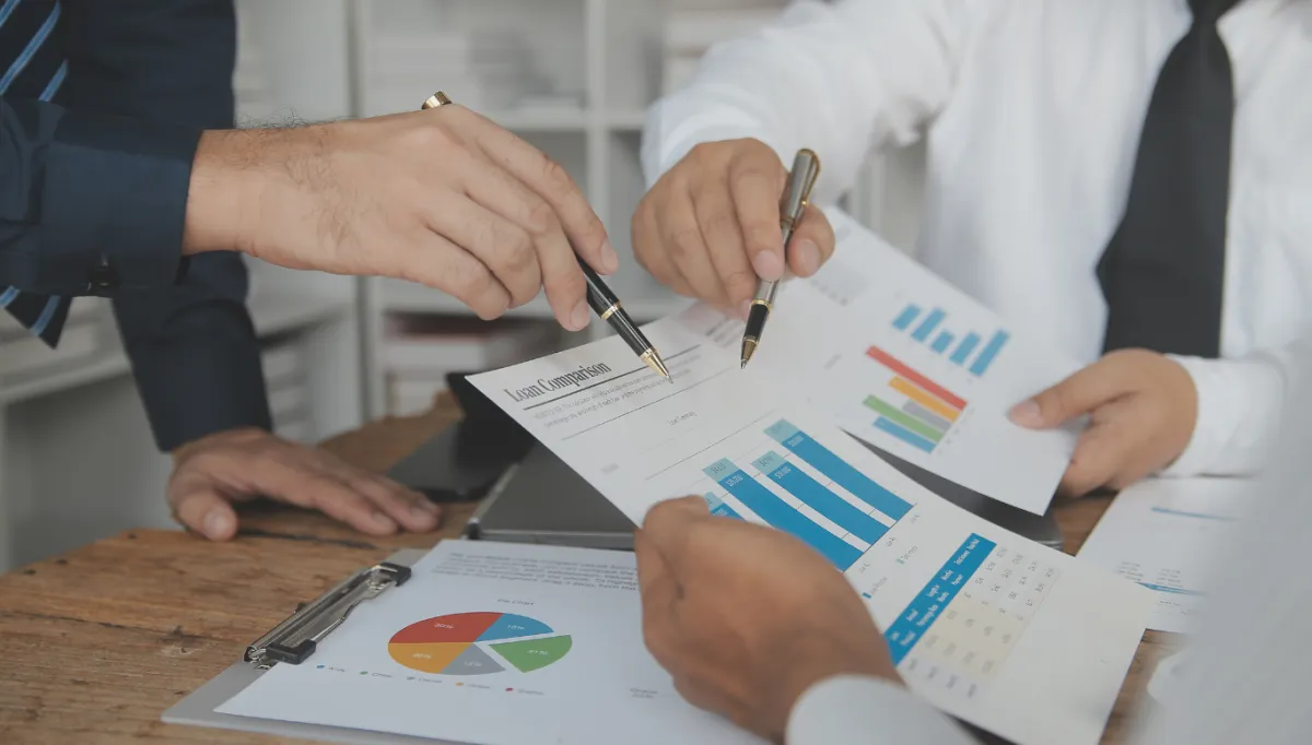 close up shot of the hands of three people duiring a discussion pointing to a paper with chars and numbers