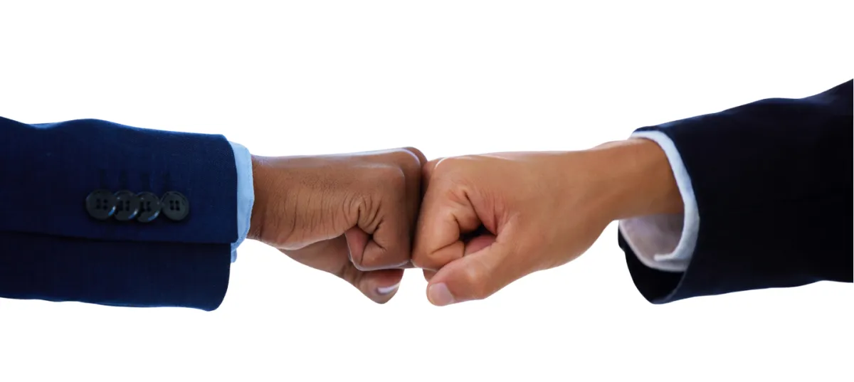 close up shot of a fist bump between two men in business suit