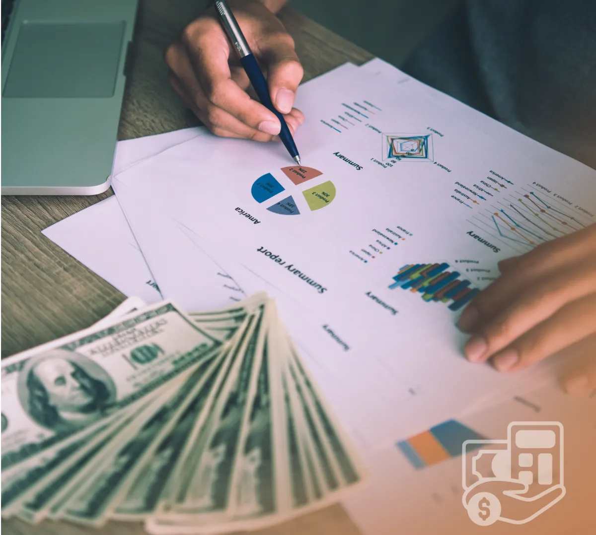 close up shot of a person's hand and a document with graphs in numbers and a fanned out money on the side