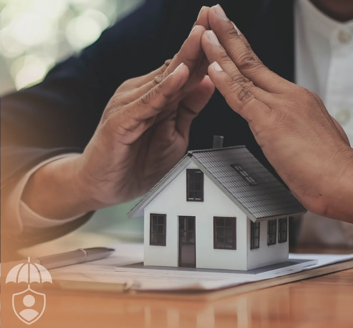 close up shot of a hand performing a house gesture over a miniature model of a house