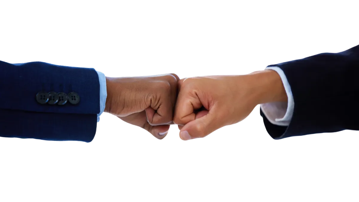 close up shot of a fist bump between two men in business suit