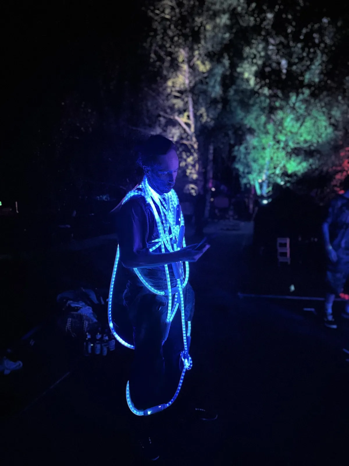 Two performers entwined with soft ropes mid-performance on a theater stage with dramatic side lighting.