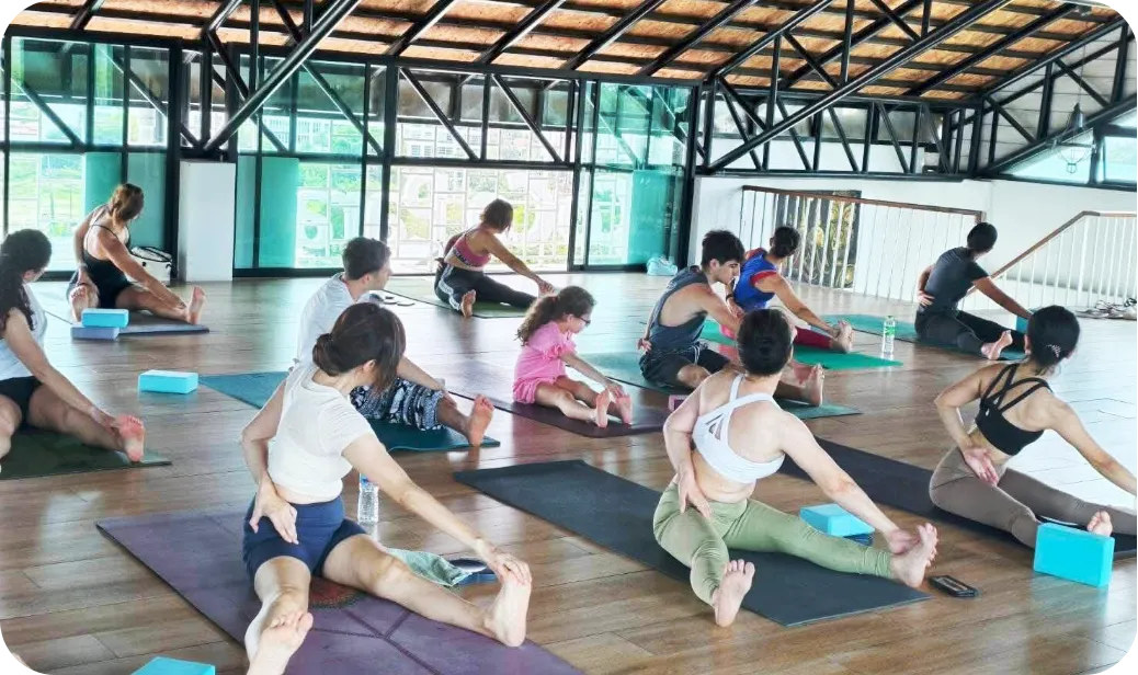 Group yoga session in a bright studio, illustrating how high performers benefit from structured recovery beyond holidays to regain clarity and focus.