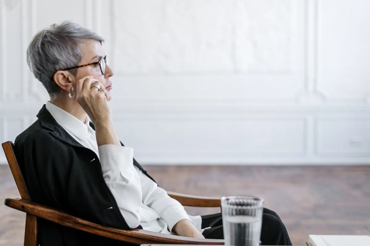Participant seated thoughtfully in a professional setting, reflecting on how pressures at work carry into home life, reinforcing the programme’s principle that work and home are connected.
